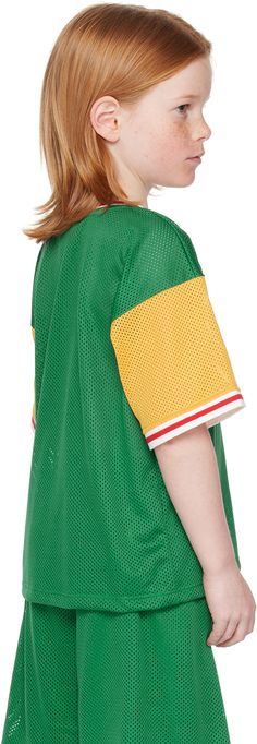 Post-consumer recycled polyester mesh T-shirt. · Striped rib knit crewneck and cuffs · Graphic and text printed at chest · Dropped shoulders · Machine-wash Supplier color: Green Model measures 48 / 121.9 cm tall and wears size 116-122. Mini Rodini Size : Child's age, child's height 56-62: 1-4M, 22-24.5 / 56-62 cm 68-74: 4-9M, 27-29 / 68-74 cm 80-86: 9M-1.5Y, 31.5-34 / 80-86 cm 92-98: 1.5-3Y, 36-38.5 / 92-98 cm 104-110: 3-5Y, 41-43.5 / 104-110 cm 116-122: 5-7Y, 45.5-48 / 116-122 cm 128-134: 7-9Y, Green Mesh Casual Top, Green Mesh Crew Neck Top, Sporty T-shirt With Ribbed Collar And Crew Neck, Sporty T-shirt With Ribbed Crew Neck, Sporty Crew Neck T-shirt With Ribbed Collar, Green Sporty Tops With Ribbed Collar, Sporty Green Top With Ribbed Collar, Retro Green Top With Ribbed Cuffs, Green Varsity Crew Neck T-shirt