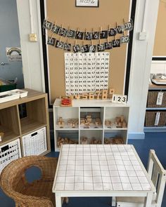 a table and chairs in a room with many items on the shelves, including letters