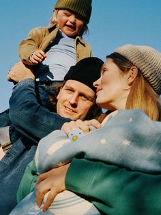 a man, woman and child sitting on top of each other