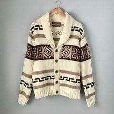 "Amazing 1970s vintage button-down cardigan sweater by Charter Oak. Fans of The Big Lebowski might find this sweater familiar! Although it's not the same Pendleton Westerley sweater that was worn in the movie, the design is quite similar and has the same vibe. The original Pendleton sweater debuted in 1972 with many companies producing their own versions with differences in the patterns and details (like the wood buttons instead of a zipper). Made with 100% virgin acrylic yarn. Made in Taiwan. Machine washable. In excellent vintage condition, just has a small stain on one of the arms and a larger but more faint blotch of discolouration on the other, as pictured. Both are hardly noticeable when worn. Men's size Large, fits on the smaller size of that (more like a men's medium). Could also f Casual Brown Cardigan With Shawl Collar, Retro Knitted Outerwear For Fall, Brown Button-up Cotton Sweater, Brown Cotton Button-up Sweater, Vintage Knitted Sweater Coat For Fall, Winter Shawl Collar Cardigan With Buttons, Beige Long Sleeve Retro Sweater, Vintage Knitted Sweater Coat With Long Sleeves, Vintage Knitted Beige Outerwear