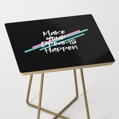 a black table with the words make your dreams happen written on it and gold legs