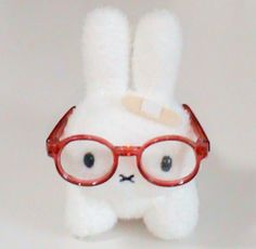 a white stuffed animal with glasses on it's face