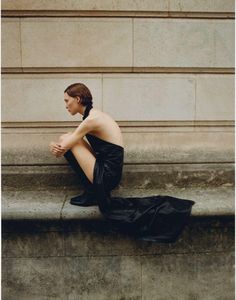 a woman in black dress sitting on steps