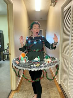 a woman is standing in the hallway holding a tray with food on it and making a surprised face