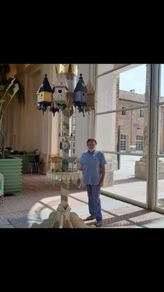 a man standing next to a tall lamp