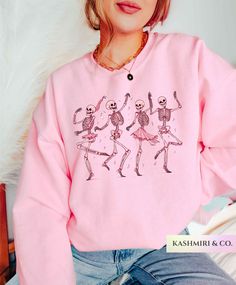 Cute Trendy "PINK DANCING SKELETONS" Sweater unisex heavy blend crewneck sweatshirt. It's available in a variety of colors. Pink Dancing Halloween Skeleton Sweatshirt, Spooky Pumpkin Sweater, Halloween Ghouls Shirt, Pumpkin Shirt, Fall Gift, Fall Shirts, Spooky  For an Oversized Look order 1 to 2 sizes larger than your normal size. Features: These garments are made from polyester and cotton.  The collar is ribbed knit, so it retains its shape even after washing.  There are no itchy side seams on Pink Halloween Sweatshirt, Trendy Pink Skull Print Top, Trendy Pink Tops With Skull Print, Trendy Pink Top With Skull Print, Pink Punk Top For Halloween, Pink Band Merch Top For Fall, Pink Long Sleeve Band Merch Sweatshirt, Pink Long Sleeve Band Merch Top, Pastel Goth Pink Long Sleeve Top