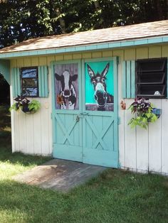 a small shed with two pictures on the door and windows in it's side