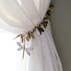 a white curtain with dragonflys attached to it