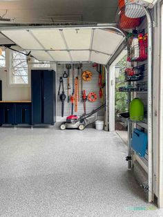 the inside of a garage with various tools and equipment in it, including an overhead car lift