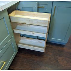 a kitchen with blue cabinets and wood flooring