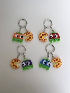 four keychains with different designs on them sitting next to each other in front of a white surface