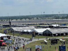 many tents are set up in the middle of an open field with people walking around