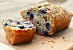 a blueberry muffin cut in half on a cutting board