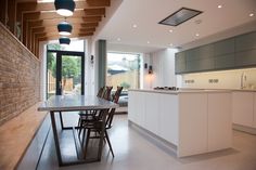 an open kitchen and dining area with white cabinets