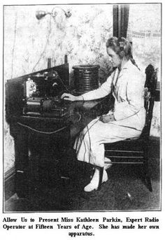 an old black and white photo of a woman sitting at a desk typing on a typewriter