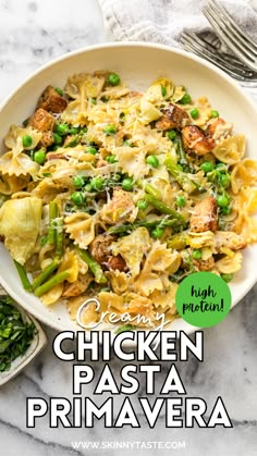 a bowl filled with pasta and peas on top of a marble countertop next to a fork