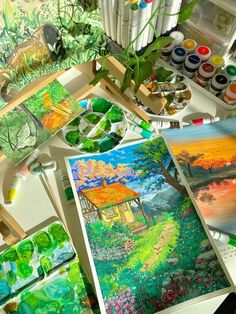 an artist's desk with paints, brushes and watercolors on the table