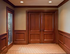 an empty room with wooden doors and carpet