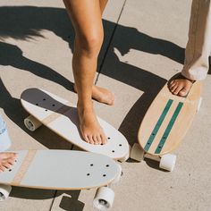 two people standing next to each other on skateboards with their feet propped against one another