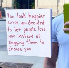 a man holding up a sign that says you look happy since you decided to let people lose you instead of begging them to choose you