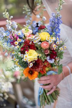 a woman holding a bouquet of flowers in her hands