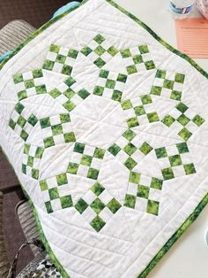 a green and white quilt sitting on top of a table