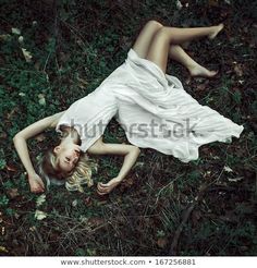 a woman in white dress laying on the ground with her legs spread out and head down