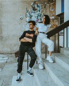 a man and woman sitting on some stairs