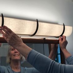 two women are working on a light fixture