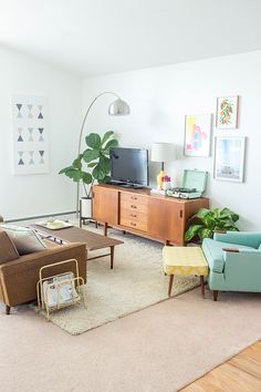 a living room filled with furniture and a flat screen tv on top of a wooden cabinet