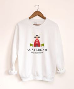 Amsterdam Sweatshirt, Windmill Sweater, Holland Hoodie, Unisex Clothes, Aesthetic Clothes ♥ PRODUCTION TIME: 1-5 days (Usually 1-2 days) ♥ SHIPPING TIME: 2-5 days (Usually 3 days) ♥ PRODUCT DESCRIPTION: Ideal for any situation, a unisex heavy blend crewneck sweatshirt is pure comfort. These garments are made from polyester and cotton. This combination helps designs come out looking fresh and beautiful. The collar is ribbed knit, so it retains its shape even after washing. There are no itchy side seams on these sweaters. ♥ CARE INSTRUCTION: Machine wash: cold (max 30C or 90F); Non-chlorine: bleach as needed; Tumble dry: low heat; Do not iron; Do not dryclean. ♥ PRINTING METHOD: DTG printing method is used for these suits. A process of printing on textiles and garments using specialized or m Unisex Clothes, Clothes Aesthetic, Dtg Printing, Travel Gifts, The Netherlands, Aesthetic Clothes, Crewneck Sweatshirt, Amsterdam, Favorite Outfit