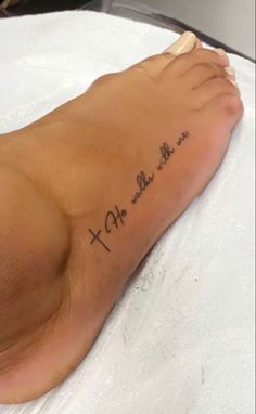 a person with a cross tattoo on their foot