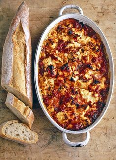 an oval casserole dish with bread on the side