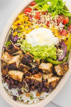 a salad with chicken, beans and rice in a bowl