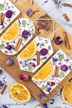 slices of oranges and spices on a cutting board with dried herbs, cinnamon sticks, and flowers