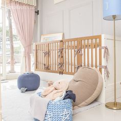 a baby crib in the corner of a room with stuffed animals and blankets on it