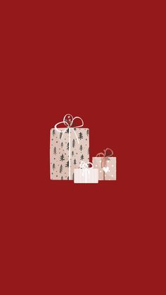 three wrapped presents sitting on top of each other in front of a red background with black and white designs