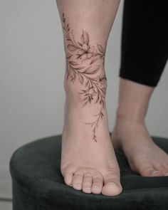 a woman's foot with a flower tattoo on it