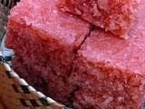 several pieces of pink cake sitting in a basket on top of a wooden table next to a wicker basket