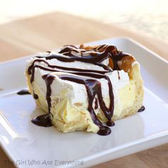 a piece of cake on a white plate with chocolate drizzled over it