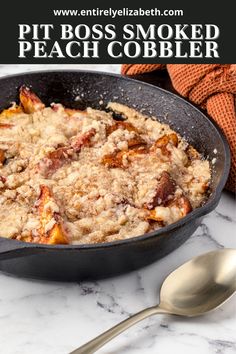 a skillet filled with peach cobbler on top of a marble counter