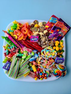 an assortment of candy and candies on a white platter with blue background, top view