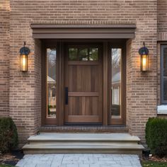 the front door of a brick house with two lights on each side and steps leading up to it