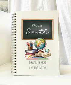 a note book with the words miss smith written on it next to a stack of books