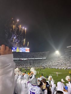 a football stadium filled with lots of people watching fireworks and confetti being thrown in the air