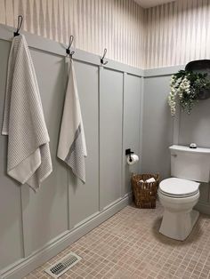 a white toilet sitting in a bathroom next to a wall mounted air freshener dispenser