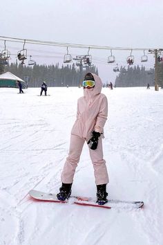 a person in pink snowsuit standing on skis