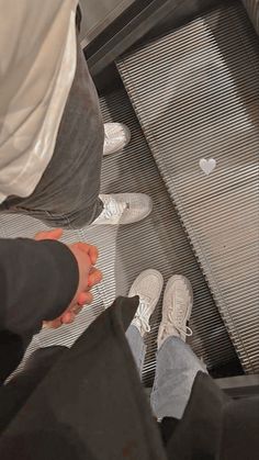 two people standing at the bottom of a metal structure with their feet in the air