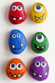 four painted rocks with eyes and mouths on them