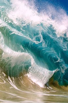 an ocean wave is breaking on the beach